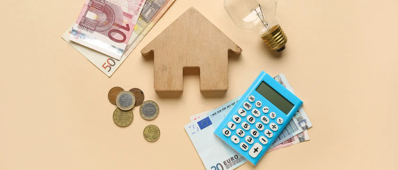 A staged scene with a small wooden house, banknotes, coins, a calculator, and a light bulb symbolizing ideas and financial management.
